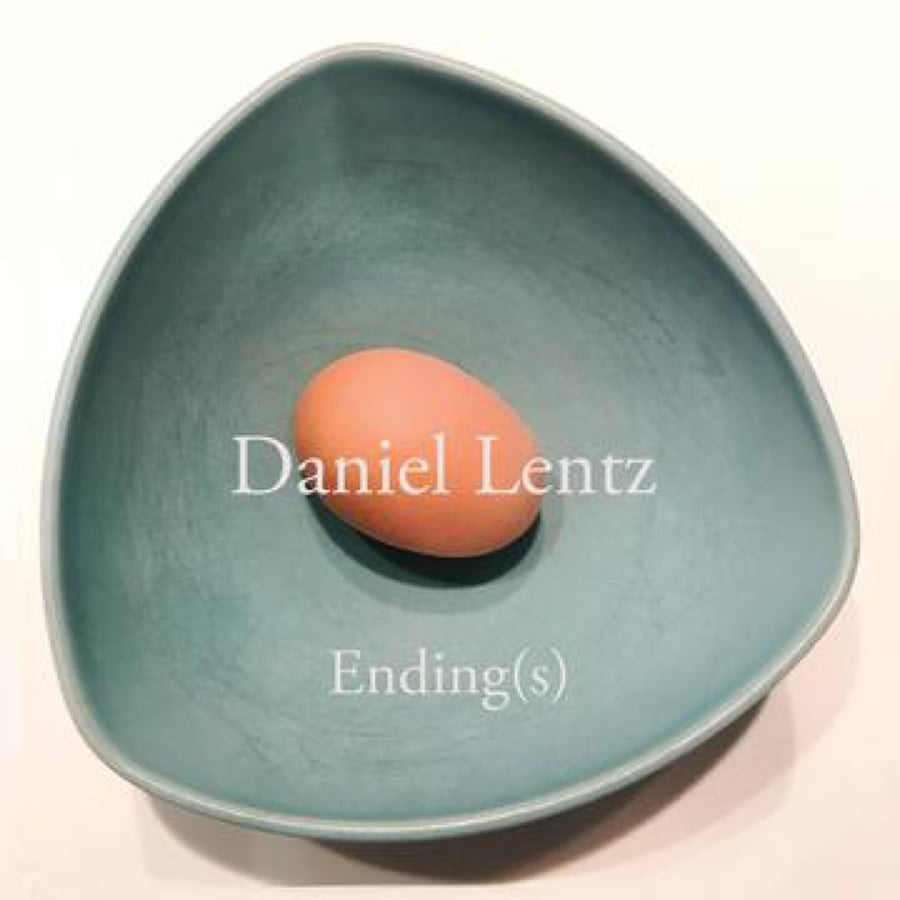 A cover image of a CD with the title 'Daniel Lentz: Ending(s)'. It features a blue bowl with a single orange egg in the center, and the text is white.